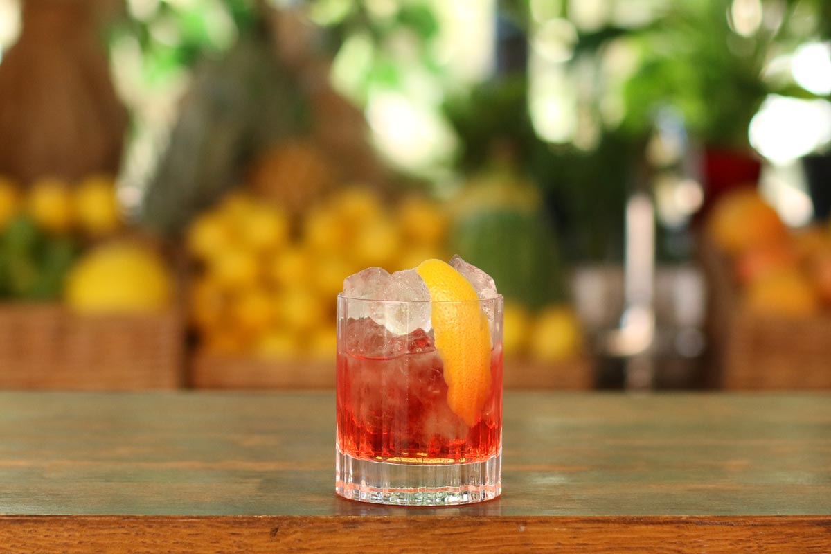 How to make A Negroni, a cocktail resting on the top of a bar