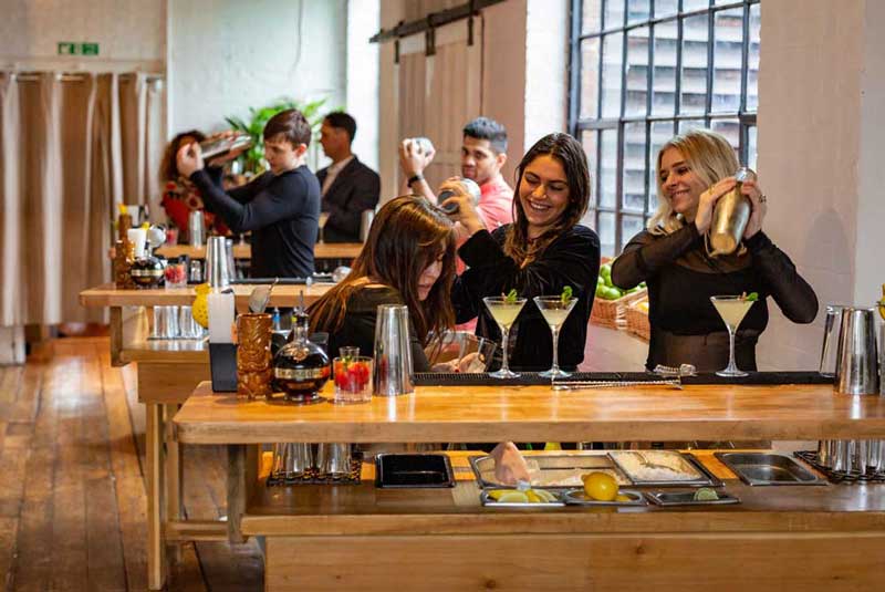 People at their own bars making cocktails in a class