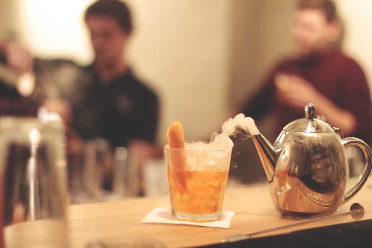 Molecular cocktail making class tea pot with on a bar with smoke coming out of it