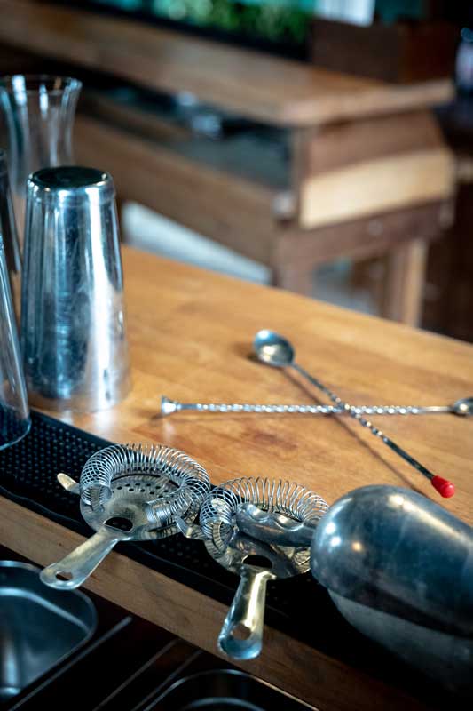 Cocktail equipment laid out on a cocktail bar top.